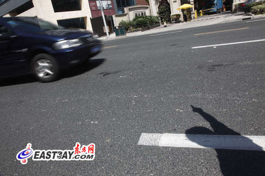 图片说明:目击者向记者指出当时事发情形,现场仍留有血迹。